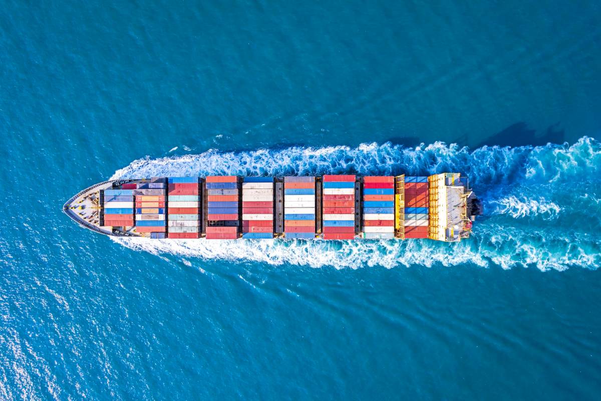 Cargo ship sails on a blue sea.