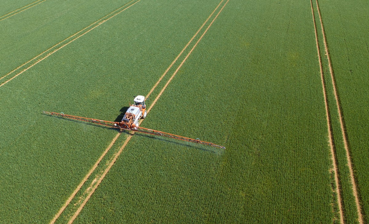 Crop sprayer in field aerial view; agtech