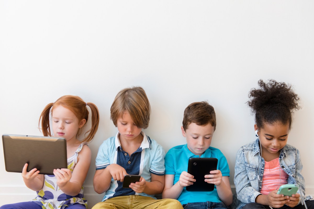 Image of four children using tablets and smartphones