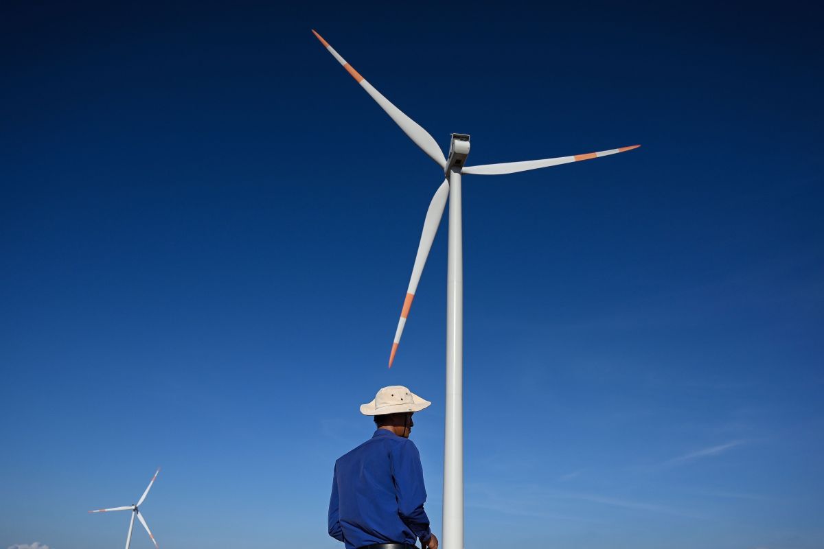 A man in front of a wind turbine in Vietnam